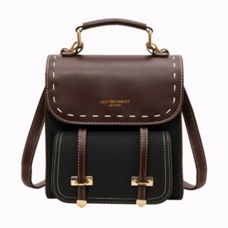 Small vintage black and brown backpack with straps on the front and handle on a very light grey background.