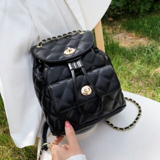 Sac à dos femme petit format matelassé noir avec un fond une chaise blanche dans un jardin