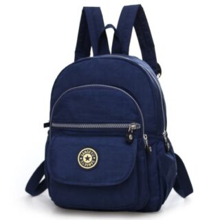 Waterproof mini backpack for women in solid navy blue. The backpack has four pockets of different sizes. One with velcro and three with zips. On the pocket with the velcro, there is the logo of the bag. The bag has a handle to hold it on a hook and two loops to carry it on the back.
