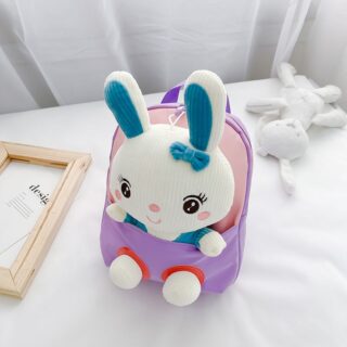 Sacs à dos d'école en peluche de lapin pour enfants blanc et violet avec un fond un lit blanc