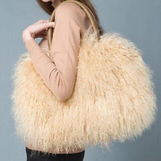 Handbag in fur and beige artificial leather with a background a mannequin wearing the bag with a grey background