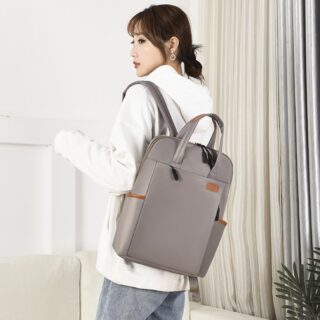 Waterproof backpack for business women in grey with a woman carrying the bag