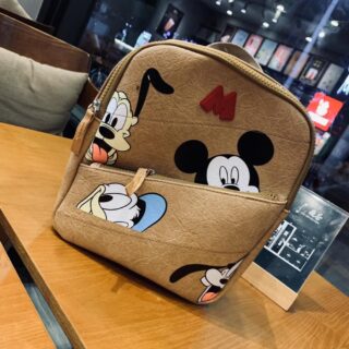 Mickey Mouse mini backpack for children in beige with a wooden table bottom