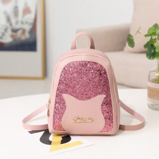 Pink girl's sequinned mini backpack with a white table background, frame and beige sofa