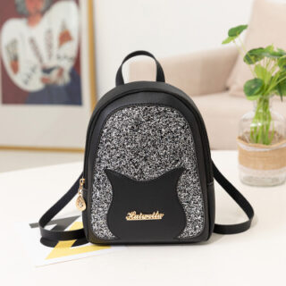 Mini sequin backpack for girl in black with a background of a sofa, a frame and a vase with a green plant