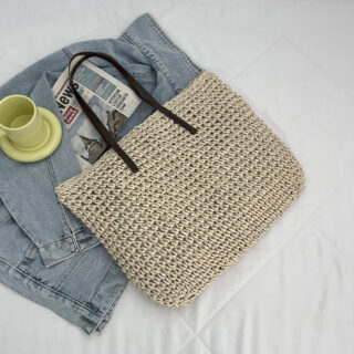 Bohemian woven straw beach bag for women in beige with a white bed and a denim jacket