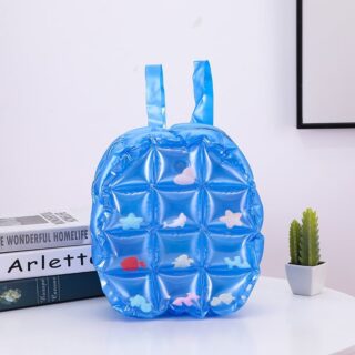 Inflatable backpack perfect for back to school blue with a little pot and cactus inside and books on a table in a house