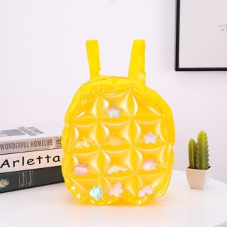 Yellow inflatable backpack on a table with books and a cactus